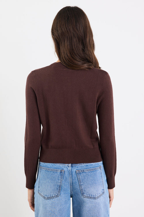 Person wearing a brown long-sleeve top and blue jeans on a white 
background
col_pattern