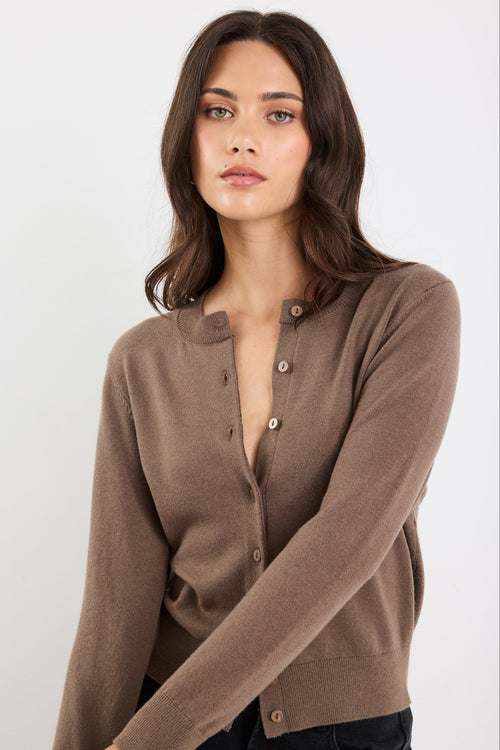 Woman wearing a brown cardigan against a white background