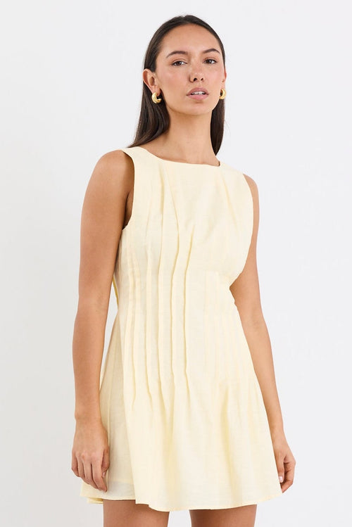 Woman wearing a light yellow dress on a white background