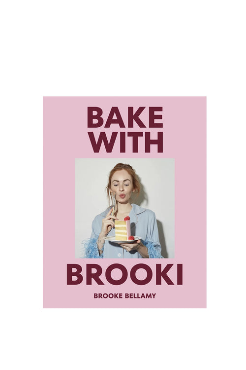 Book cover of 'Bake with Brooki' by Brooke Bellamy with a pink background and photo of a woman holding a cake.