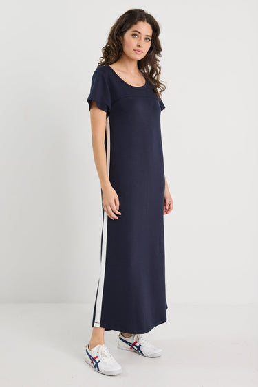 Woman wearing a navy dress with white stripes on a white background
