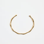 bamboo-inspired gold-plated cuff bangle with textured design, photographed flat against a white background.