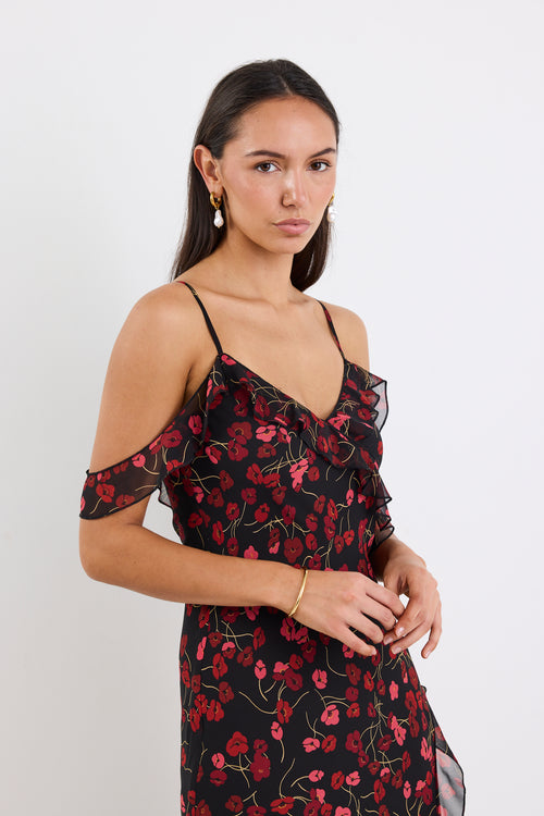 Woman wearing a black floral dress against a white background