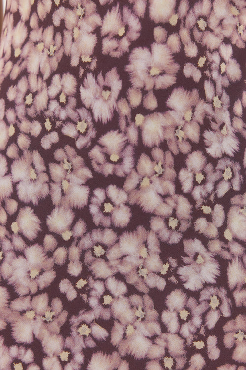 Floral patterned fabric with purple and white flowers on a dark background