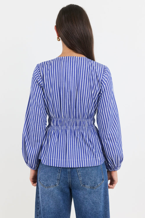 Person wearing a blue and white striped shirt and jeans on a white background