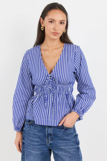 Woman wearing a blue and white striped blouse with long sleeves on a white background