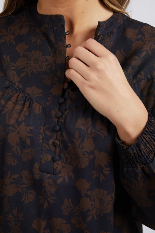 model wears a black floral top