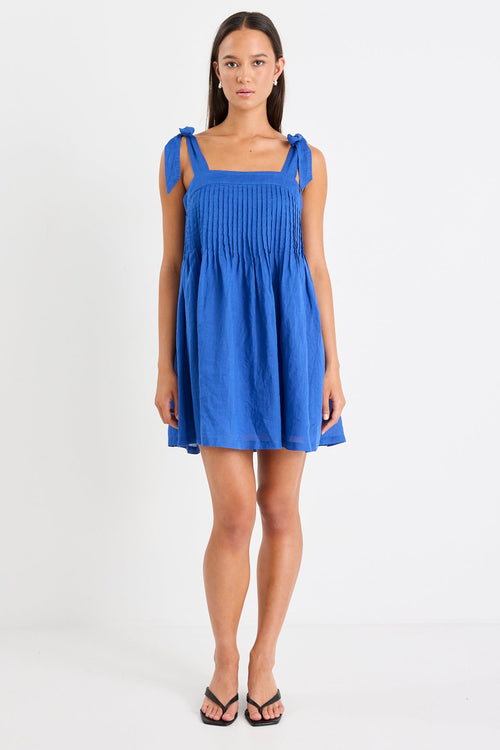 Woman wearing a blue ramie mini dress with bow straps