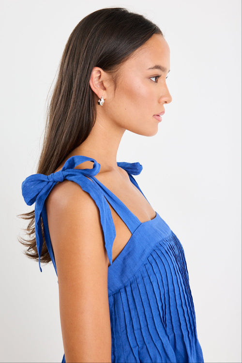 Woman wearing a blue ramie mini dress with bow straps