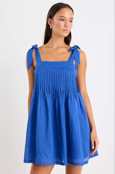 Woman wearing a blue ramie mini dress with bow straps