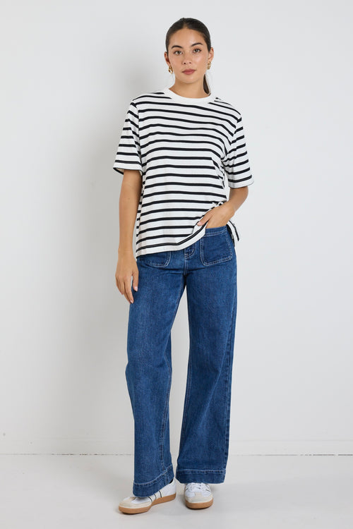 Model wears black and white stripe top with jeans