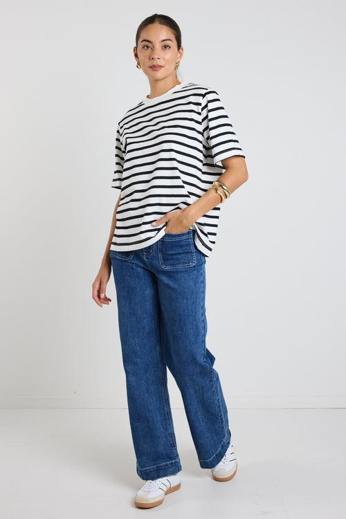 Model wears black and white stripe top with jeans