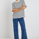 Model wears black and white stripe top with jeans