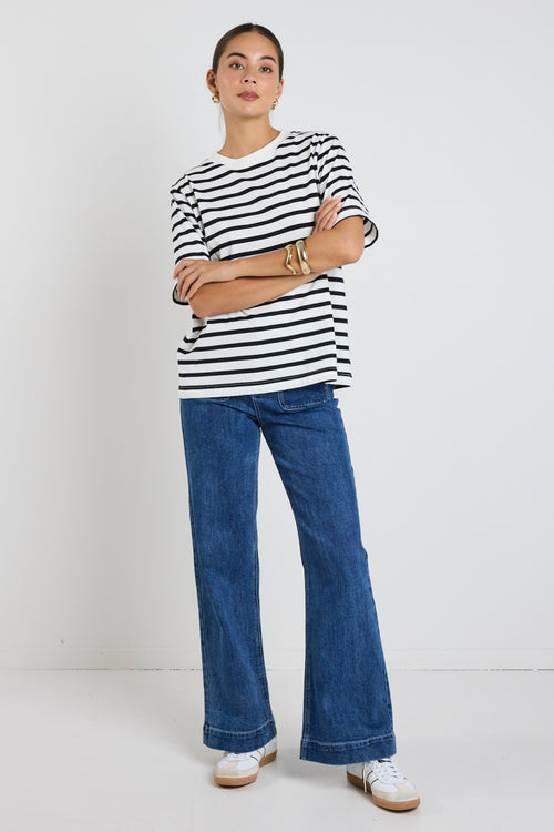 Model wears black and white stripe top with jeans