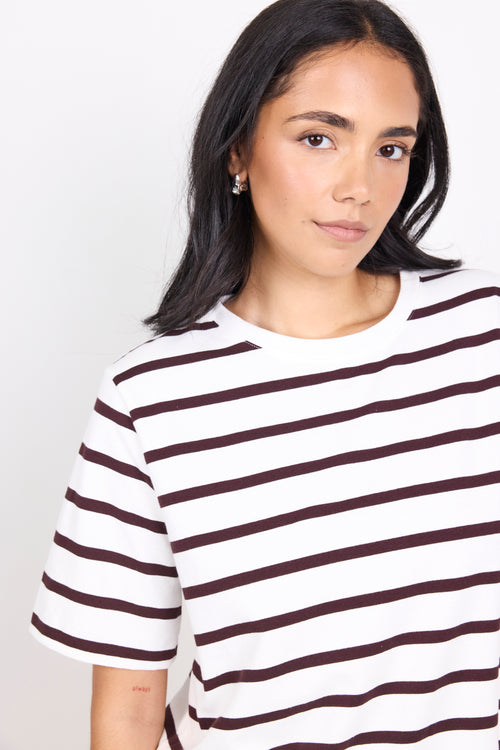 Woman wearing a black and white striped shirt against a plain background