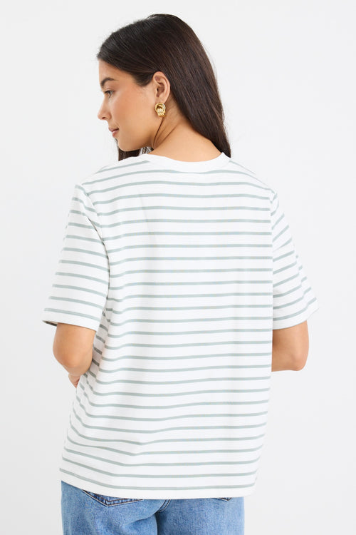 model wears a khaki and white stripe tee with light blue jeans