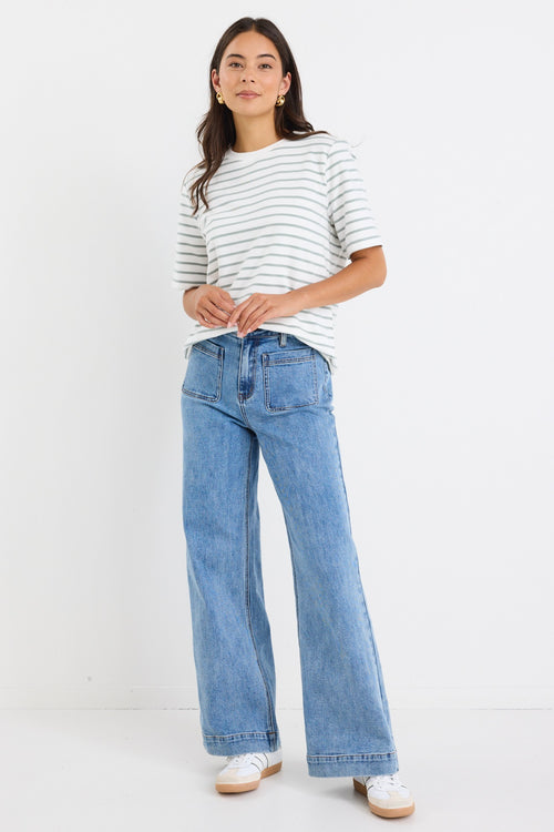 model wears a khaki and white stripe tee with light blue jeans