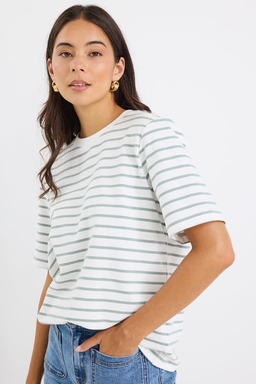 model wears a khaki and white stripe tee with light blue jeans