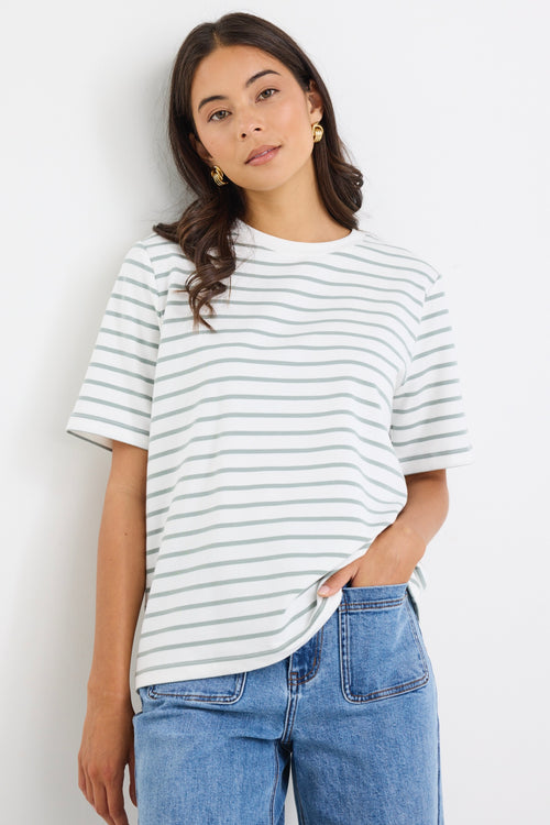 model wears a khaki and white stripe tee with light blue jeans