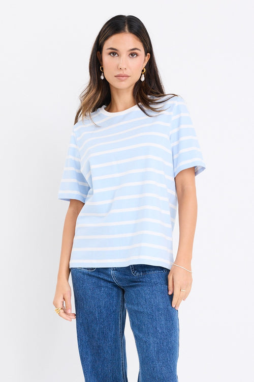 model wears a pale blue t shirt with white stripes
