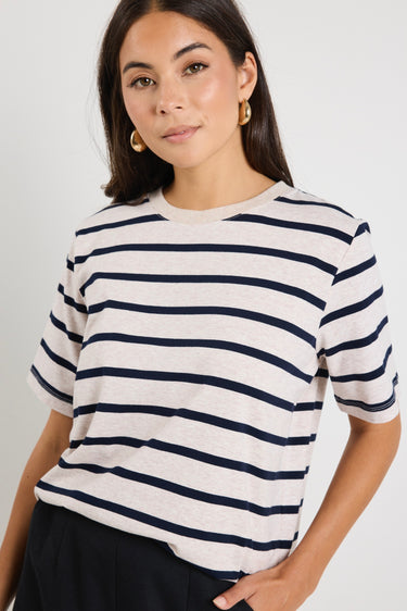 model wears ecru tee shirt with navy stripes styled with black pants