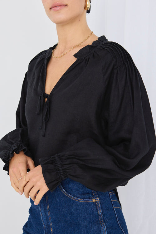 model wears a black linen long sleeve top