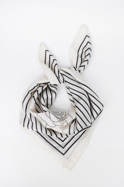 A white square scarf with black stripes and a black line-art rose design, styled in a knot on a plain white background.