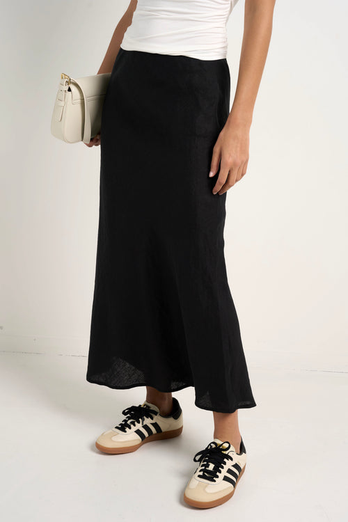 model wears a black linen midi skirt