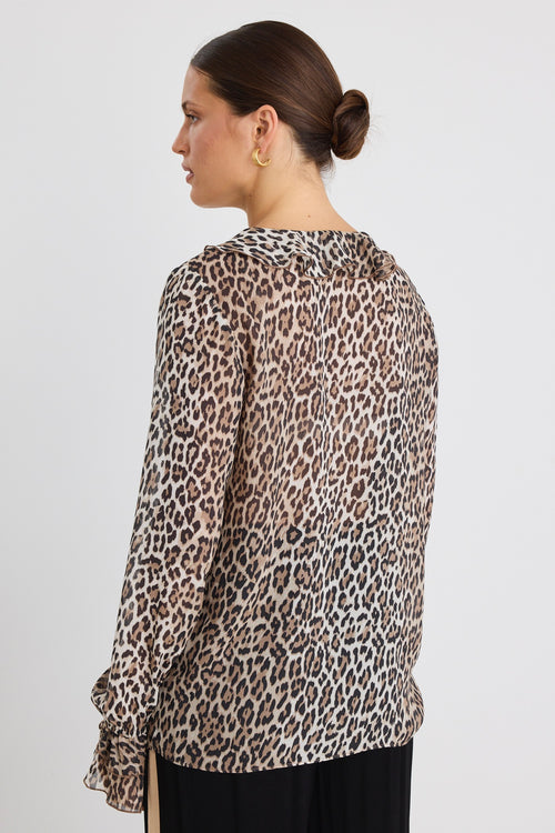 model wears a brown leopard with black pants