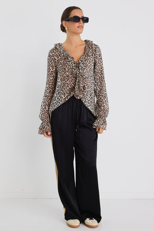 model wears a brown leopard with black pants