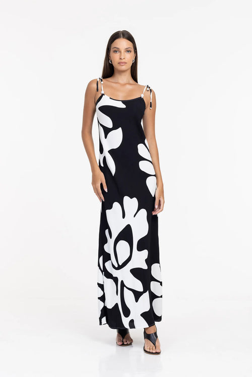 Woman wearing a black dress with white abstract patterns on a white background