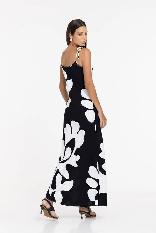 Woman wearing a black dress with white floral patterns on a white background