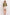 A woman modeling an olive green oversized short-sleeve top and beige shorts against a plain white studio background.