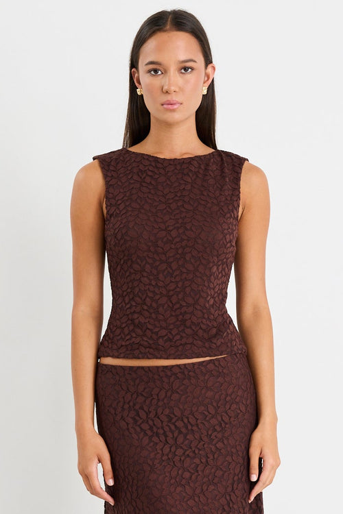 Woman wears a brown lace top