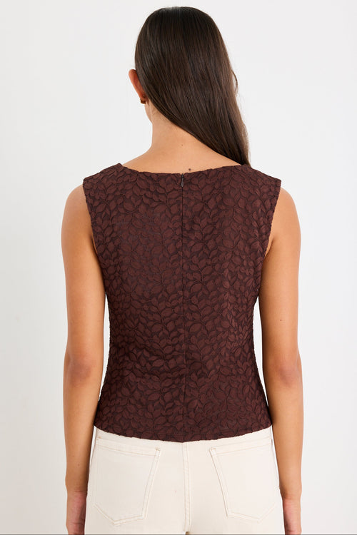 Woman wears a brown lace top