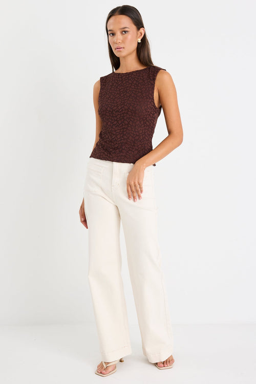 Woman wears a brown lace top