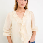 cream frill top and blue jeans