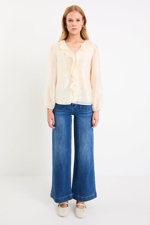 cream frill top and blue jeans