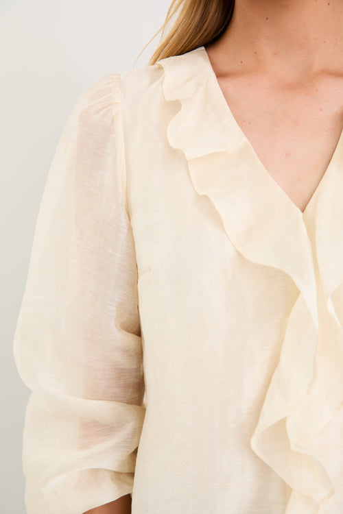 cream frill top and blue jeans