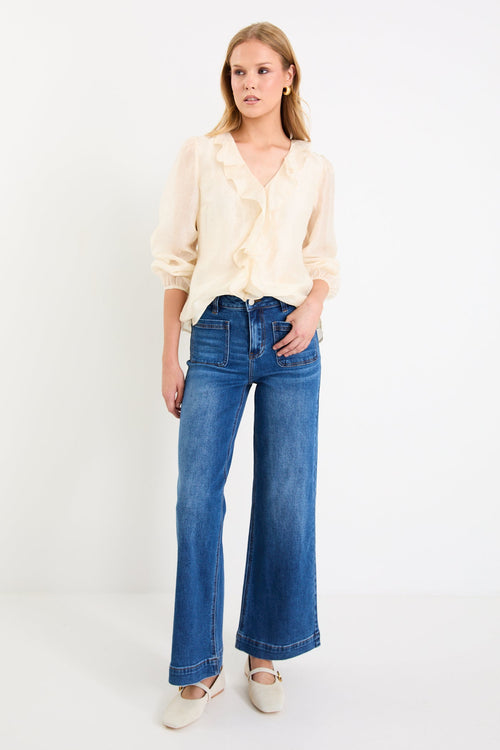cream frill top and blue jeans