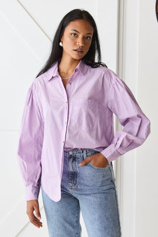 model wears purple button up long sleeve shirt and blue jeans