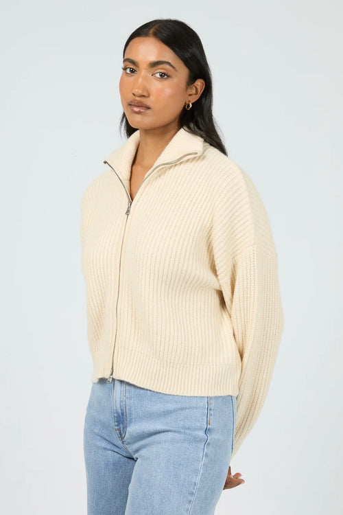 Model wears a vanilla long sleeve knit zip up cardigan