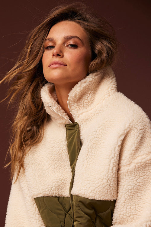 model wears a cream green jacket