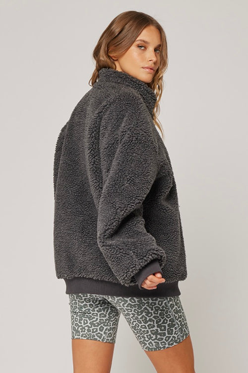 model wears a grey jumper