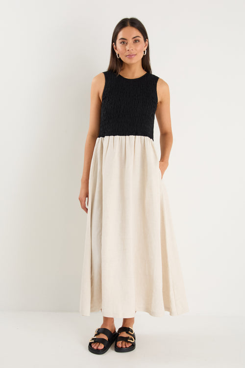 Woman wearing a black top and white skirt on a white background