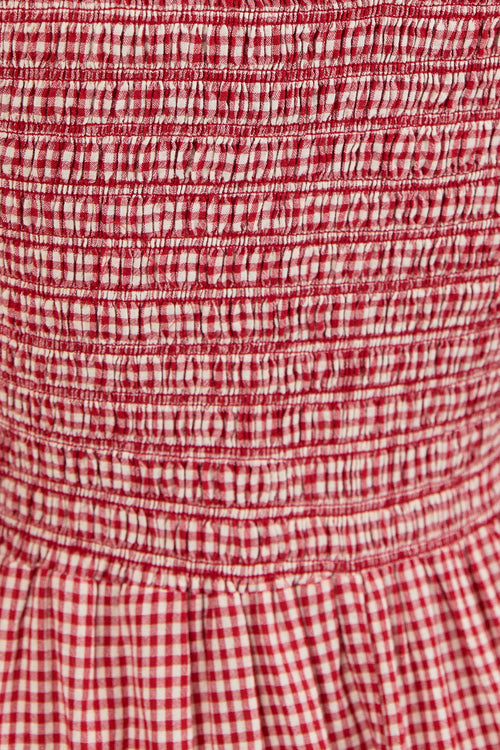 Close-up of a red and white gingham patterned fabric with horizontal smocked ruching.