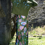 Person wearing a green floral dress and green cardigan outdoors.