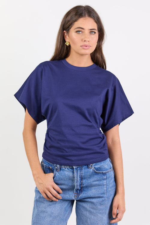 Woman wearing a blue tee and jeans on a white background