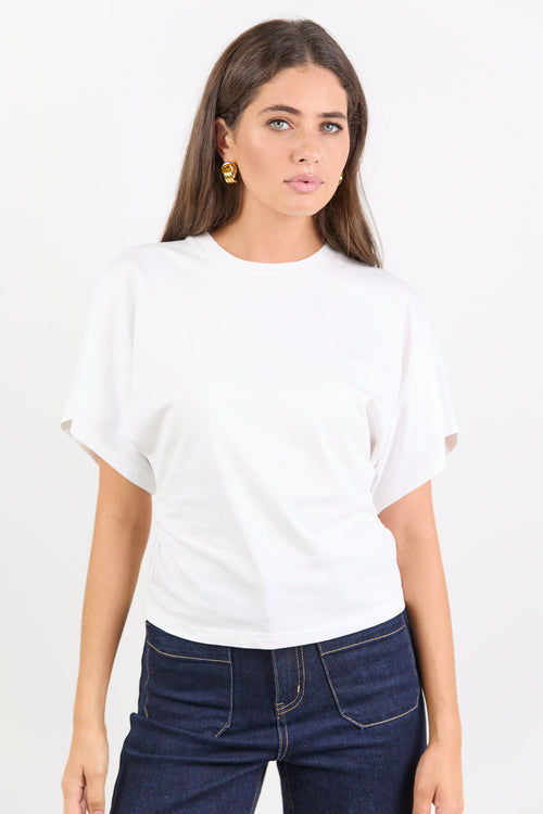 Woman wearing a white t-shirt and dark blue jeans on a white background