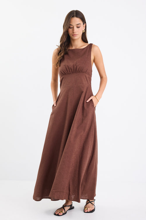 A chocolate brown dress with strappy sleeves and a shirred back for a flattering fit. Made from a breathable blend of 45% Linen and 55% Cotton, and fully lined for comfort.